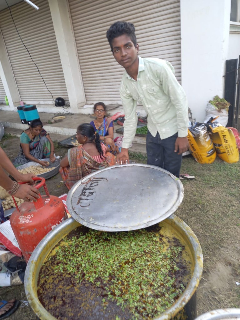 Volunteers preparing sabzi in a large pot