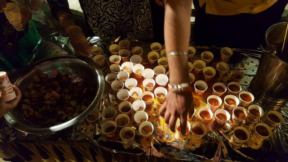 Volunteers arranging cups of prasad for distribution